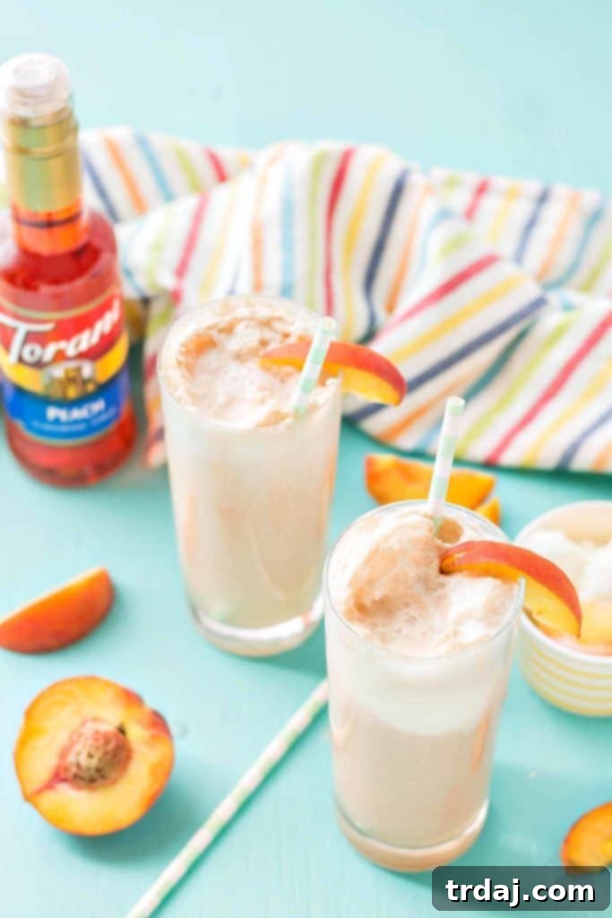 Glass of Peaches and Cream Soda with fresh peach slices and ice, a perfect summer refresher.