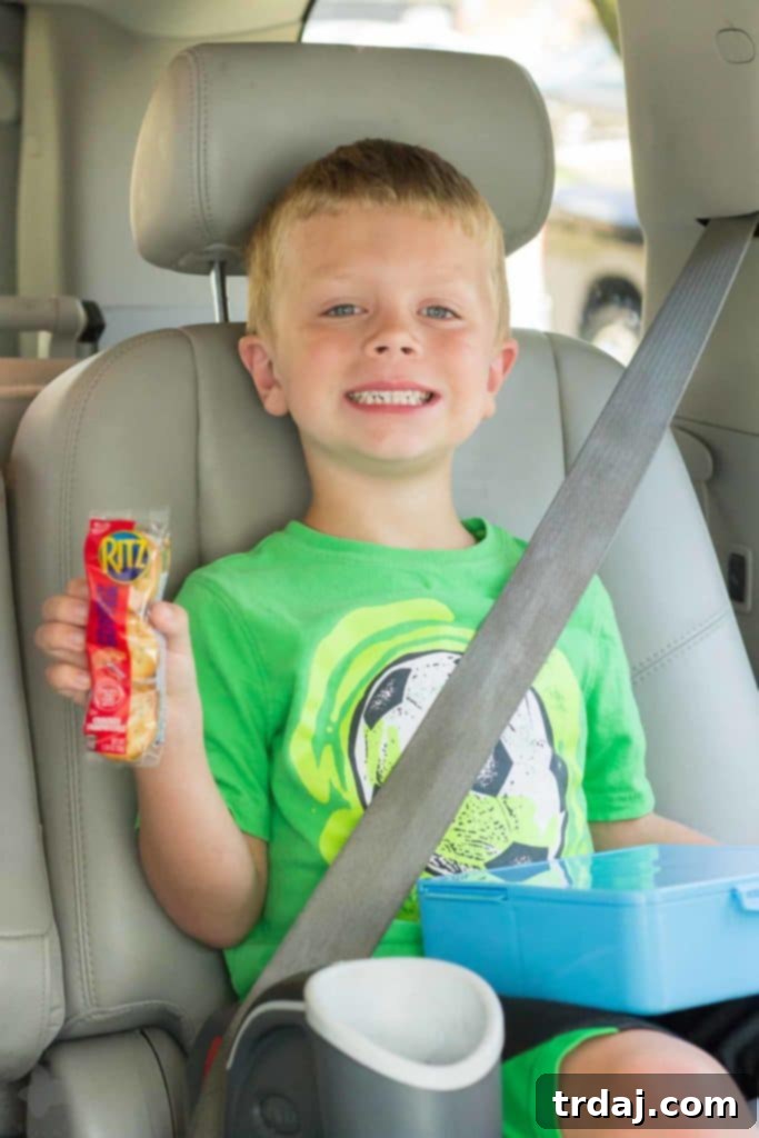 Child's hands holding a pack of RITZ Filled Cracker Sandwiches, ready for a snack
