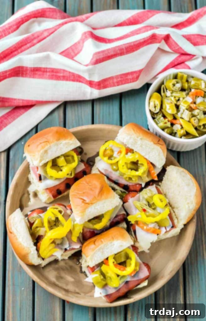 Windy City Smoked Italian Sausage Sliders 3 Close-up shot of two Chicago Style Italian Smoked Sausage Sliders, showcasing the melted provolone and giardiniera.