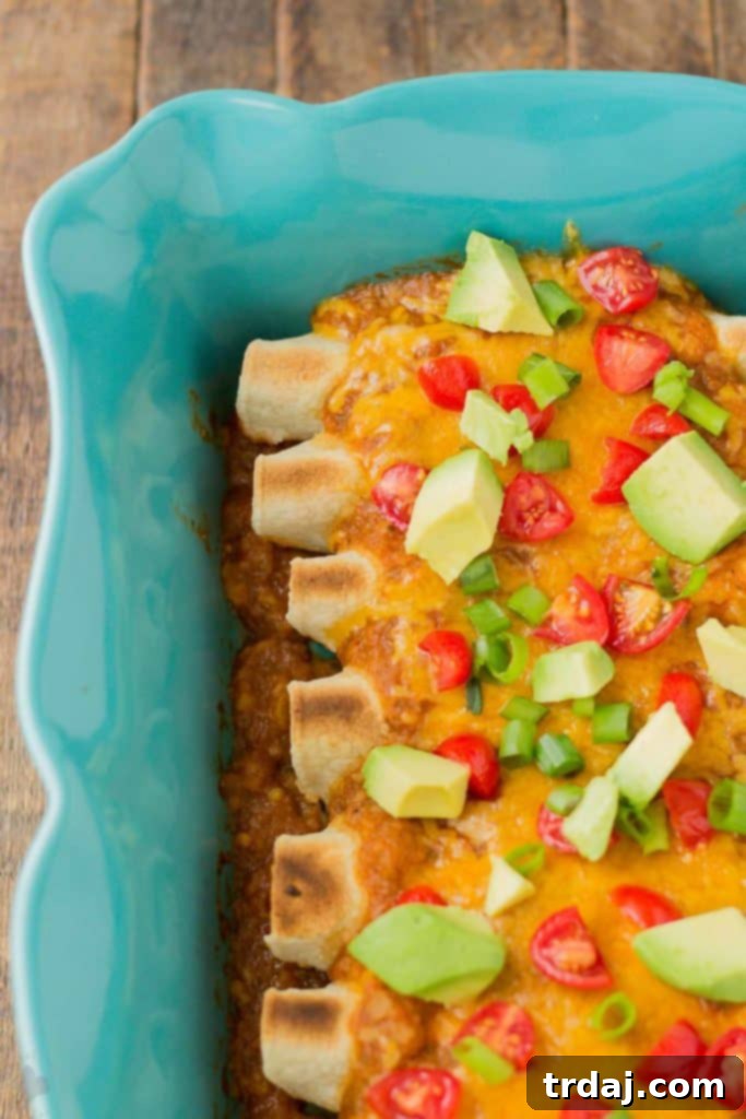 Close-up of freshly prepared Chipotle Chicken Enchiladas with a rich sauce, ready for the oven.