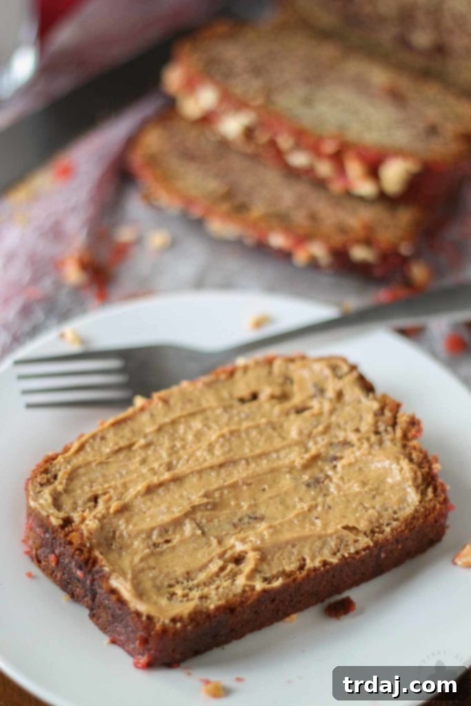 Close-up of a moist slice of homemade Peanut Butter and Jelly Banana Bread with peanut butter marbling and fruit jelly swirls.