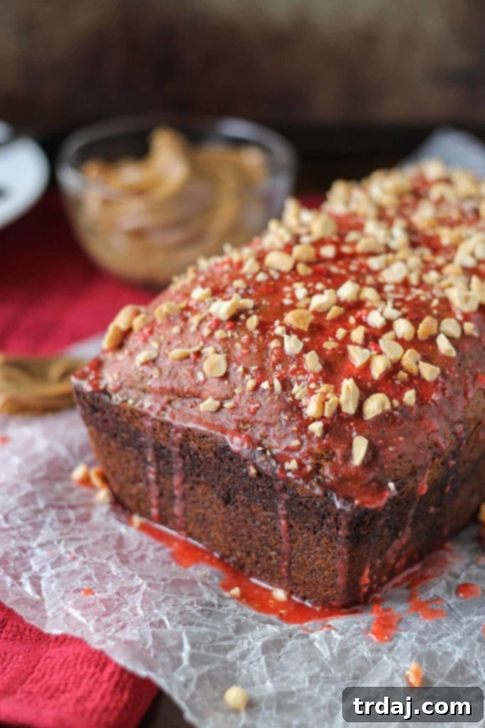 A whole loaf of Peanut Butter and Jelly Banana Bread, freshly baked, with a golden crust and a hint of jelly on top.