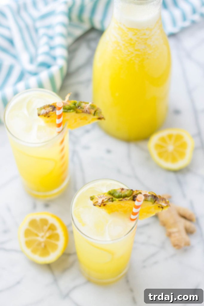 Zesty Pineapple Kick 5 Glasses of Pineapple Ginger Lemonade on a wooden surface, ready to be enjoyed.
