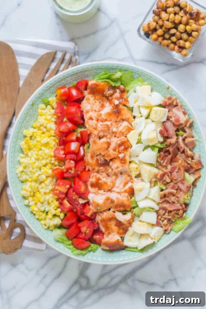 Close-up of a beautifully plated BBQ Salmon Cobb Salad with Avocado Ranch Dressing, highlighting the fresh ingredients and inviting colors.