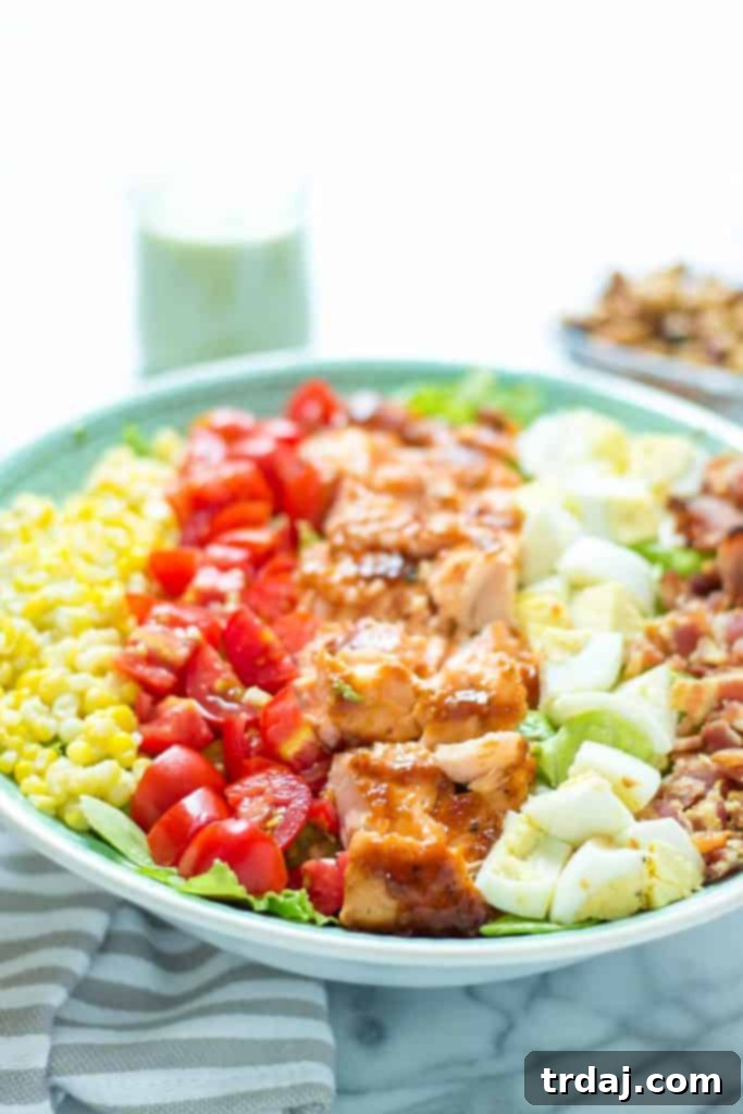 Another perspective of the BBQ Salmon Cobb Salad, showcasing the artful arrangement of the fresh, colorful ingredients before mixing.