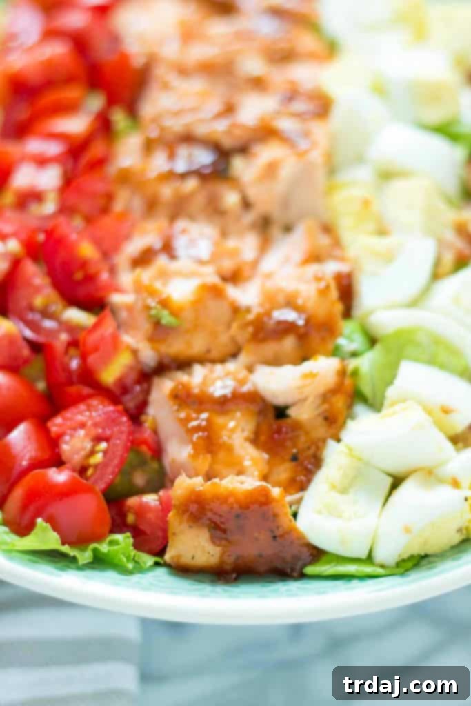 A closer view of the perfectly cooked BBQ salmon, showcasing its glazed exterior and flaky texture, ready to be added to the Cobb salad.