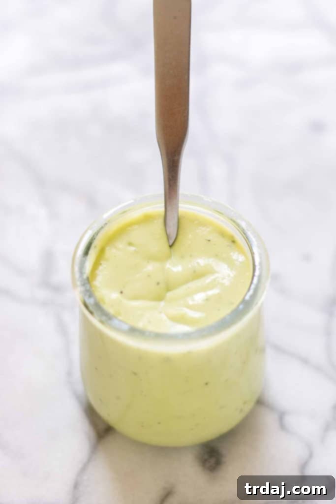 A bowl of creamy, vibrant green Avocado Ranch Dressing, perfectly blended and ready to drizzle over the BBQ Salmon Cobb Salad.