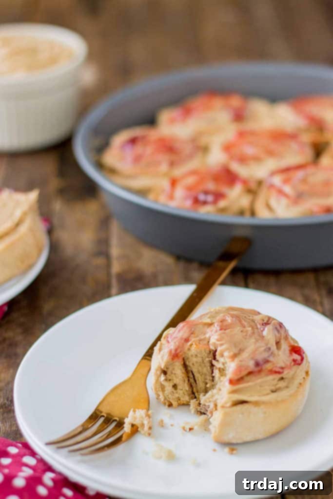 A selection of delicious Peanut Butter and Jelly Breakfast rolls on a serving platter, showcasing their enticing frosting and golden hue. | Strawberry Blondie Kitchen