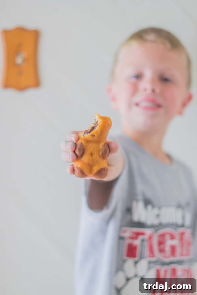 A child enthusiastically eating a TEDDY SOFT BAKED Filled Snack, enjoying the delicious treat.