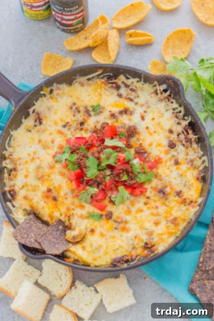 Delicious Chorizo Queso Fundido dip with melted cheeses, savory chorizo, and El Yucateco hot sauce, perfect for game day appetizers.