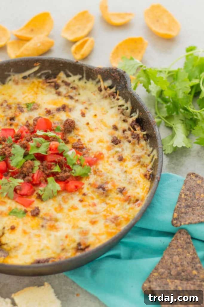 Close-up shot of Chorizo Queso Fundido in a cast iron skillet, garnished and ready to serve, an ideal appetizer for football season.