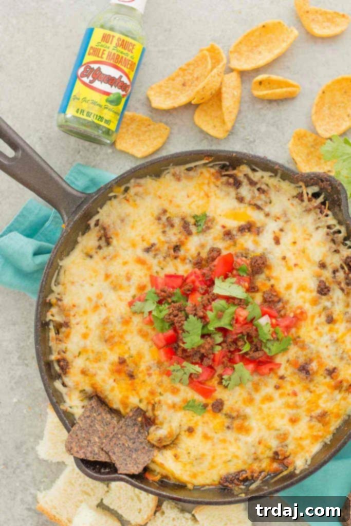 A large skillet of Chorizo Queso Fundido with dipping chips, ready to be enjoyed at a party or game day.
