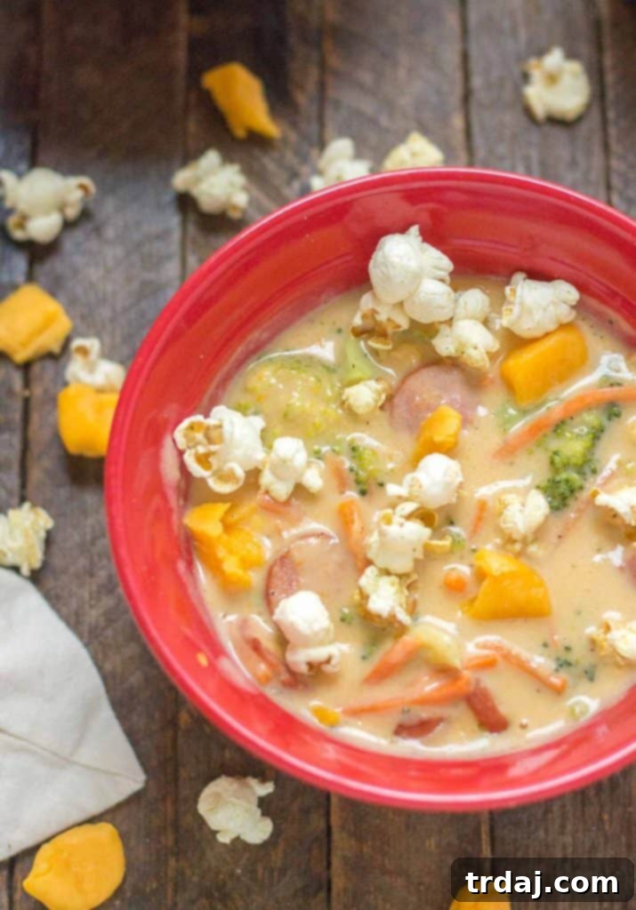 A bowl of Smoked Sausage and Beer Cheese Soup topped with popcorn and cheese curds