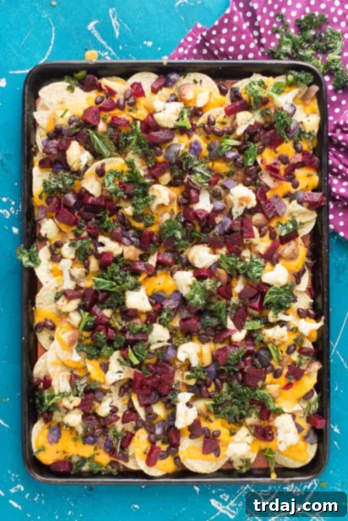 Fall Bounty Sheet Pan Nachos have butternut squash nacho cheese sauce, black beans, kale, roasted cauliflower and beets to give you the ultimate in snacking with all of Fall's delicious produce! | Strawberry Blondie Kitchen