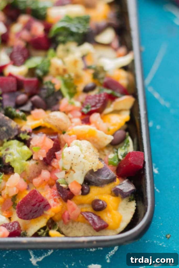 Fall Bounty Sheet Pan Nachos have butternut squash nacho cheese sauce, black beans, kale, roasted cauliflower and beets to give you the ultimate in snacking with all of Fall's delicious produce! | Strawberry Blondie Kitchen
