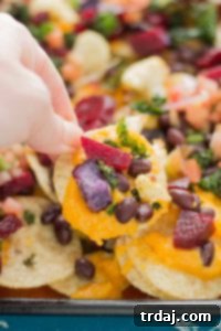 Fall Bounty Sheet Pan Nachos have butternut squash nacho cheese sauce, black beans, kale, roasted cauliflower and beets to give you the ultimate in snacking with all of Fall's delicious produce! | Strawberry Blondie Kitchen