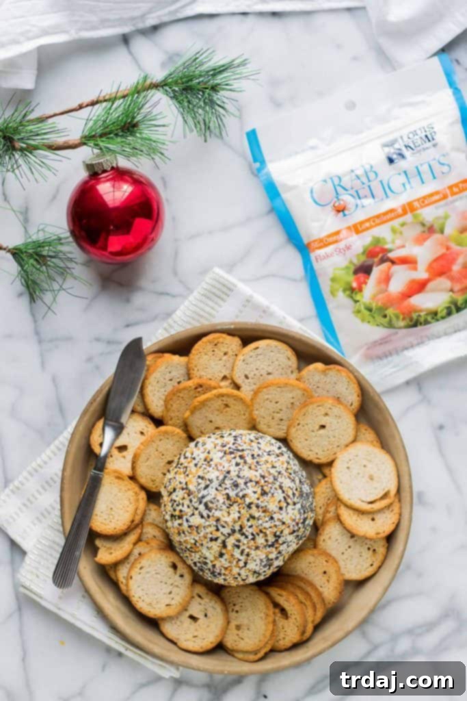 A vibrant Crab and Everything Bagel Cheese Ball, beautifully garnished and ready to serve on a festive platter with crackers.