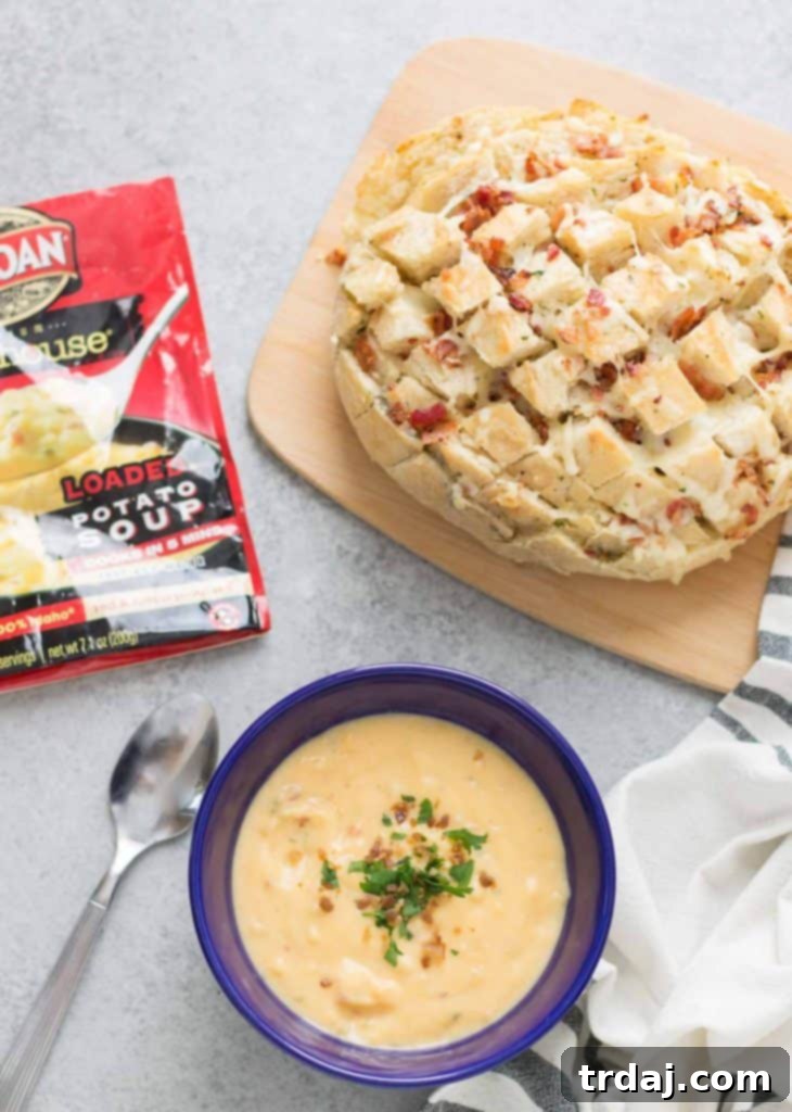 Delicious Cheddar Bacon Ranch Pull Apart Bread next to a hearty bowl of Idahoan Steakhouse Loaded Potato Soup, ready for a comforting winter meal.