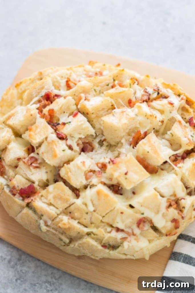 Overhead shot of Idahoan Steakhouse Soup ingredients and a partially prepared Cheddar Bacon Ranch Pull Apart Bread on a rustic wooden table.
