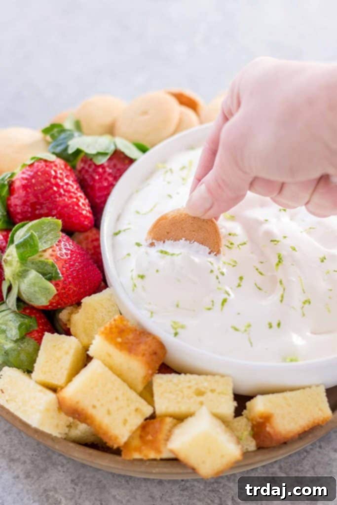 Overhead shot of Key Lime Pie Dip with a bowl of dippers, including berries