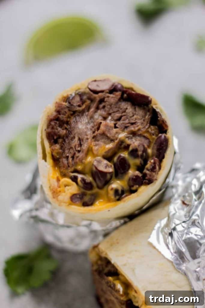A perfectly rolled Braised Beef Nacho Burrito with cheese sauce