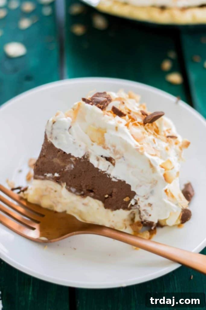 A full Chocolate Coconut Cream Pie, perfectly set and adorned with fluffy whipped cream, toasted coconut, and chocolate shavings. An inviting overhead view of a whole Chocolate Coconut Cream Pie, beautifully decorated with swirls of whipped cream, toasted coconut, and chocolate sprinkles.