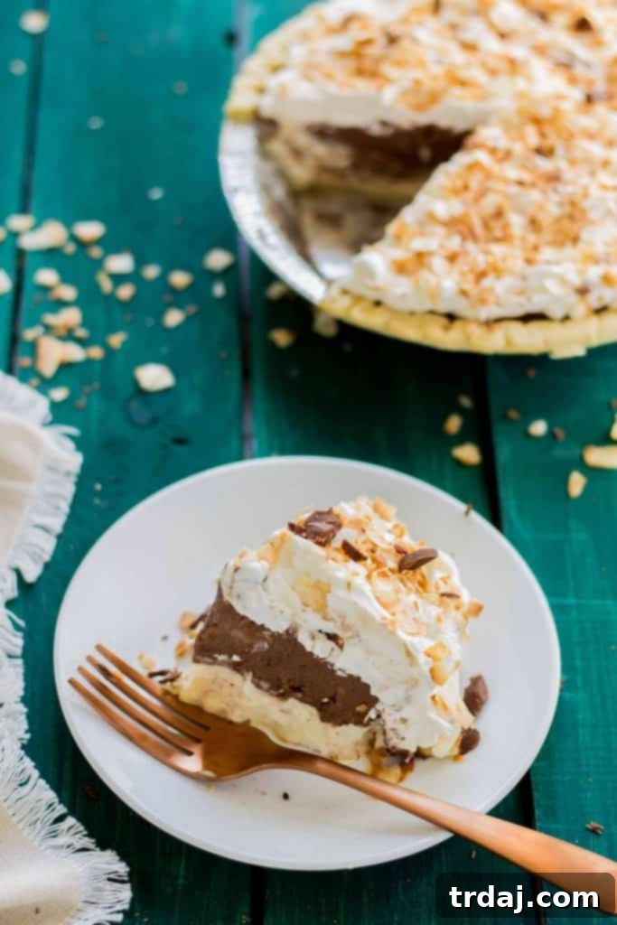 An artfully decorated Chocolate Coconut Cream Pie, ready to be served and enjoyed. A beautifully composed top-down shot of the fully assembled Chocolate Coconut Cream Pie, showcasing its artistic decoration of whipped cream, toasted coconut, and chocolate.