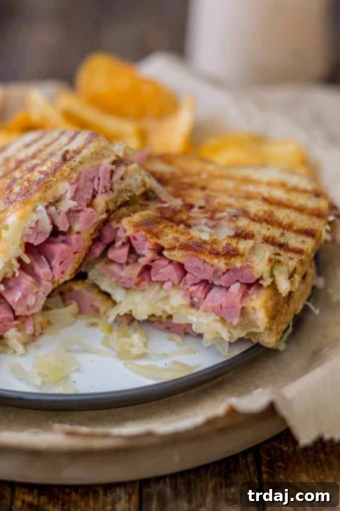 Close-up of an Epic Reuben Sandwich, showing the crispy grilled rye bread and a peek of the filling