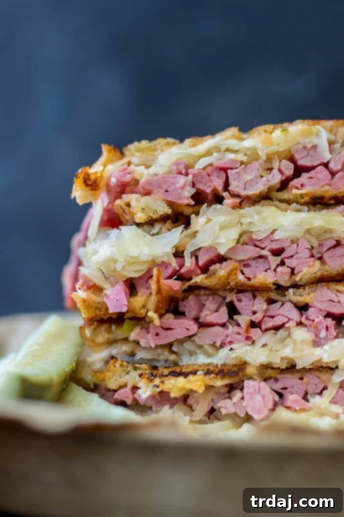 Close-up of a freshly made Epic Reuben Sandwich, showcasing the juicy corned beef and melted cheese