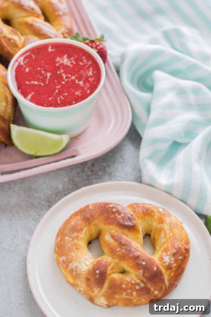 Homemade Soft Pretzels with Strawberry Margarita Sauce Dip Soft Pretzels artfully arranged around a bowl of vibrant Strawberry Margarita Sauce, emphasizing the delicious pairing.