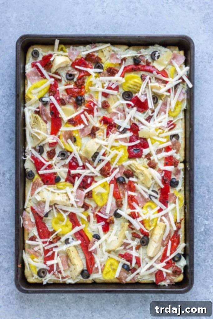 Antipasto Pizza ingredients layered on a crescent roll crust before baking