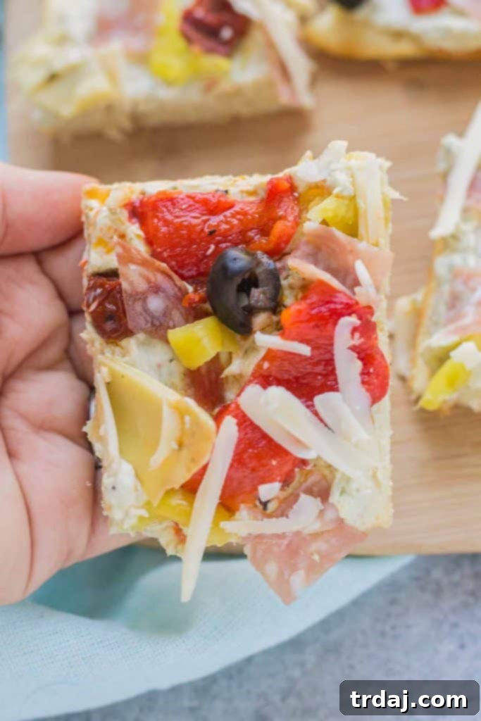 Several slices of Antipasto Pizza neatly arranged on a serving board