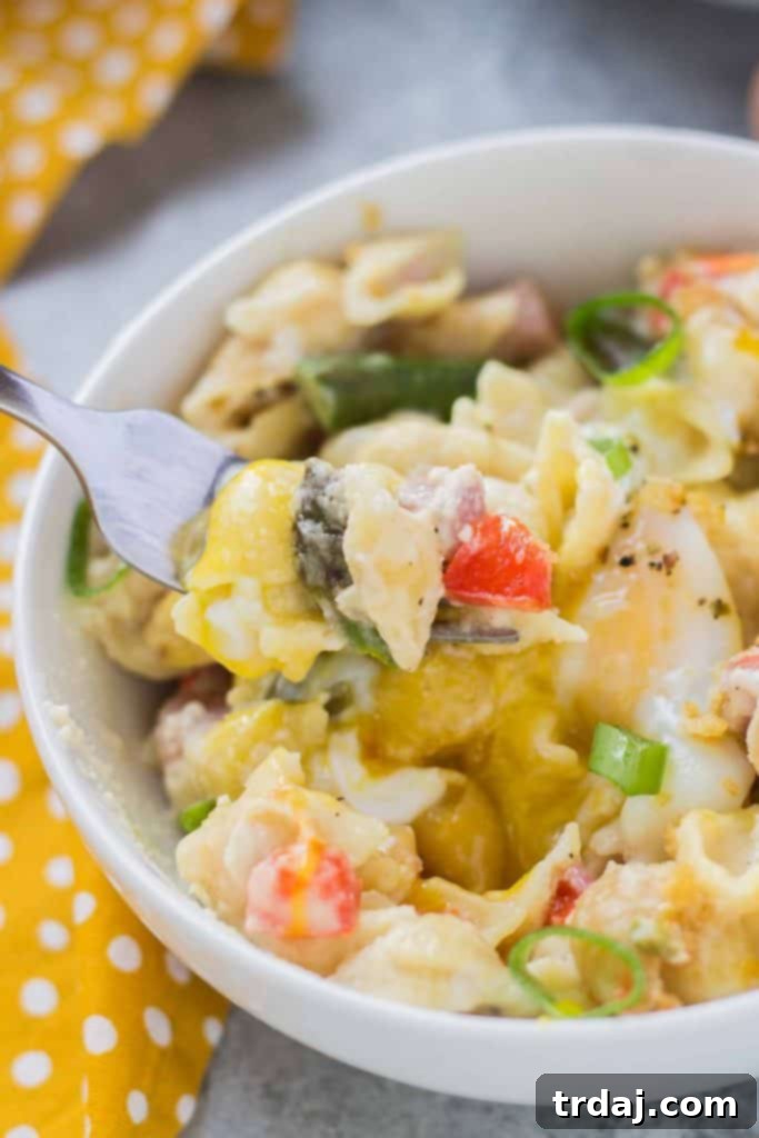 A generous serving of Breakfast Macaroni and Cheese, highlighting the gooey cheese and perfect egg.