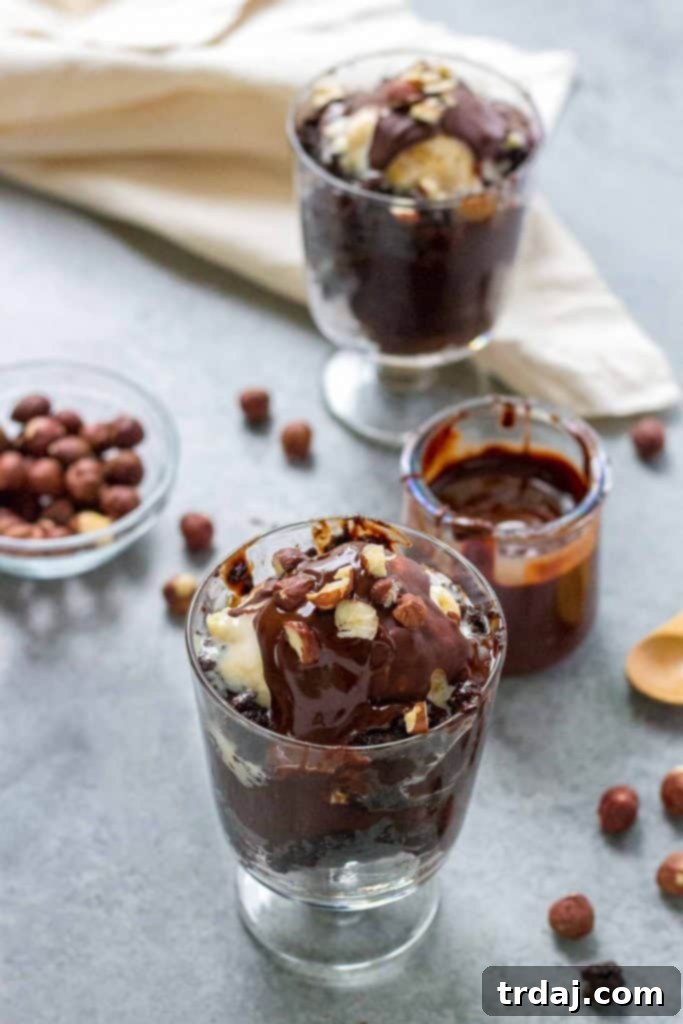 Three individual servings of Hazelnut Pudding Cake, each topped with ice cream and a drizzle of homemade hazelnut magic shell