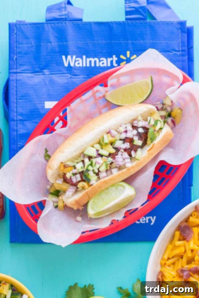 Two Hawaiian BBQ Hot Dogs on a wooden cutting board, ready to serve