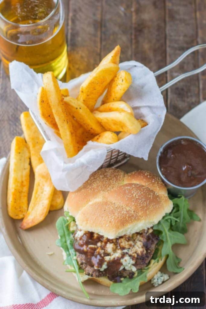 A stacked Peppercorn Blue Cheese Burger with Cherry Sauce, ready to be enjoyed.