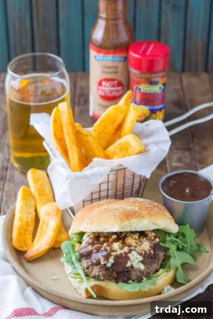 A beautifully presented Peppercorn Blue Cheese Burger with Cherry Ketchup, featuring a vibrant spread of the unique sauce.